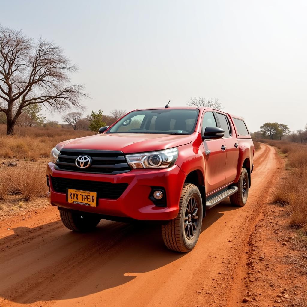 Toyota Hilux cũ màu đỏ đang đổ trên đường địa hình